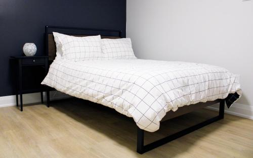 a bed with a white and black blanket on it at Urban Haven: 2BR/2BA+Office, Kitchen, Dining in Newcastle
