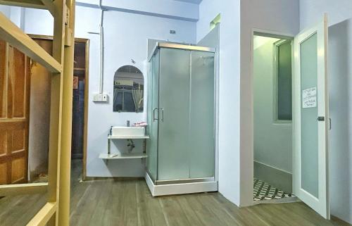 een badkamer met een glazen douche en een wastafel bij Paradiso in Ho Chi Minh-stad