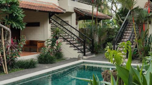 a house with a swimming pool in the yard at Kanma Resort in Ubud