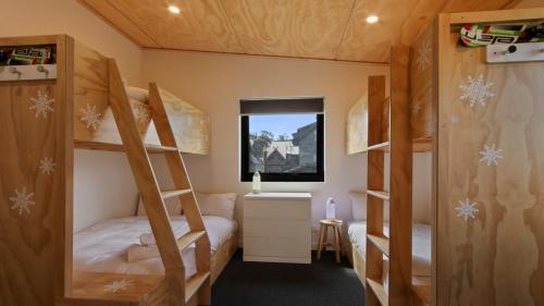 a bedroom with two bunk beds and a window at Woodrun in Dinner Plain