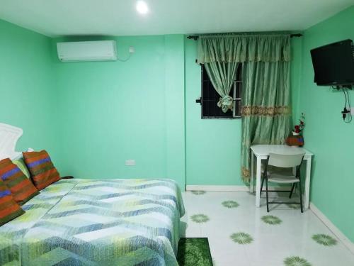a bedroom with a bed and a table and a window at Argalo Suites 2 in Laborie
