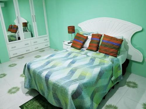 a bedroom with a bed with a colorful blanket and pillows at Argalo Suites 2 in Laborie