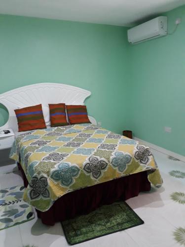 a bedroom with a bed with a quilt on it at Argalo Suites 2 in Laborie