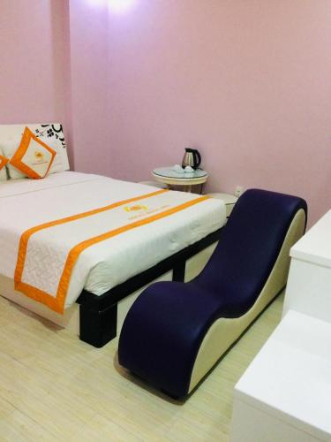 een slaapkamer met een bed met een stoel erin bij Hotel Ngọc Ánh in Ho Chi Minh-stad