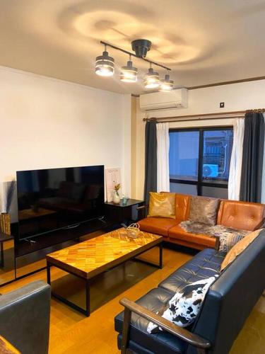 a living room with a couch and a coffee table at FUJI STAY 不二ノ宿 in Osaka