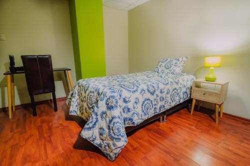 1 dormitorio con 1 cama y 1 mesa con lámpara en Casa - Huancayo - Zoológico Cerrito de la Libertad, en Huancayo