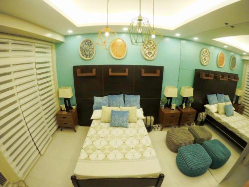 Habitación grande con 2 camas y sofá en Pico De Loro room Jacana A Bldg. en Nasugbu