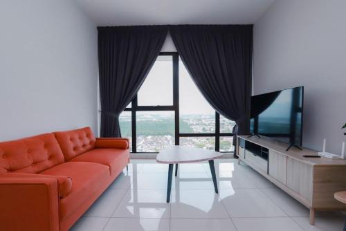 a living room with a orange couch and a tv at Southkey 2BR, 5-6 PAX, WIFI, Mid Valley JB, in Johor Bahru
