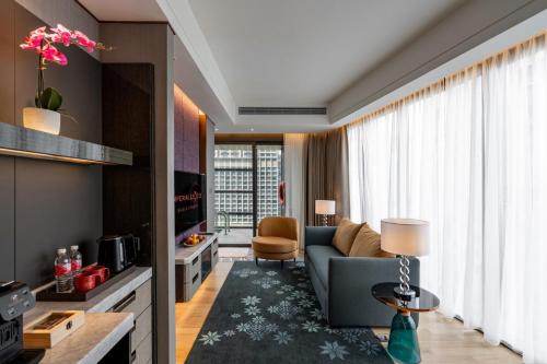 a living room with a blue couch and a chair at Imperial Lexis Kuala Lumpur in Kuala Lumpur