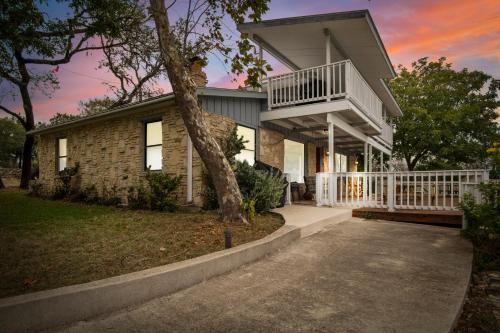 a house with a balcony and a tree at Indian Springs Lakehouse in Bandera