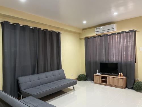 a living room with a couch and a television at Astra Bella Apartment - Unit 4 in Dumaguete