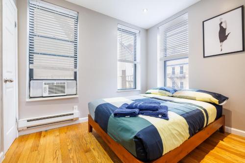 a bedroom with a bed and two windows at Home is Where the Park is in New York