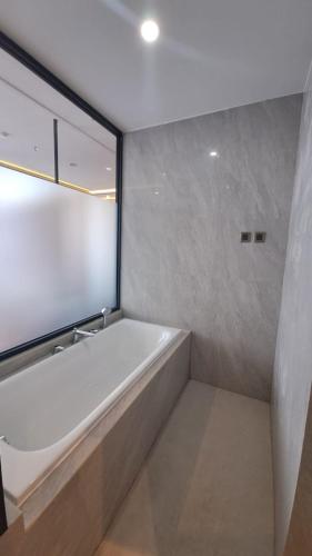 a white bath tub in a bathroom with a window at Grand Miami Hotel in Malang