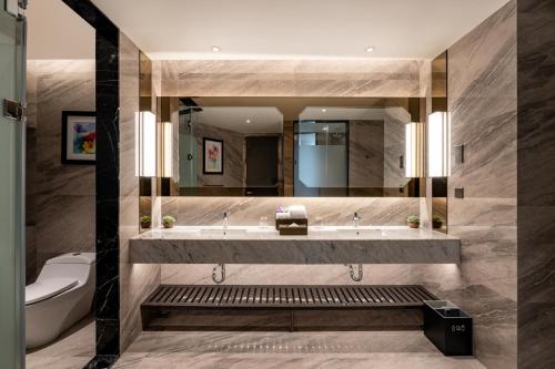 uma casa de banho com um lavatório, um WC e um espelho. em Imperial Lexis Kuala Lumpur em Kuala Lumpur