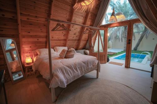 1 dormitorio con 1 cama en una cabaña de madera en شاليه ايفالو en Al Hofuf