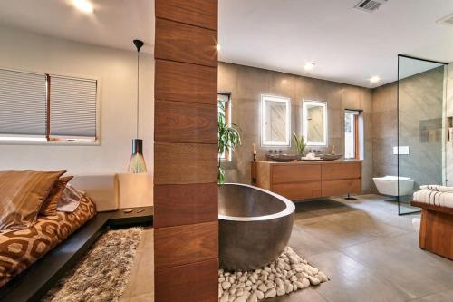 a large bathroom with a tub and a bed at Panoramic Ocean sunset Views with Heated Pool & Spa best location in San Diego
