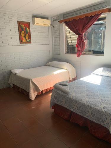 una camera con due letti e una finestra di hotel Las Cabañitas 8873-3748 a Managua