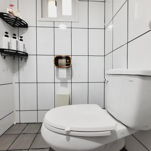 a white toilet in a white tiled bathroom at 1978 stay in Seoul