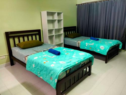 a bedroom with two beds with blue sheets at ป็อปปูล่าคอนโด เมืองทองใกล้อิมแพค สะดวกสบาย in Ban Bang Phang