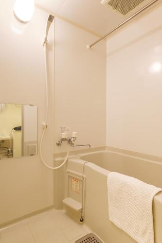 a white bathroom with a tub and a sink at Nakajima Park Hotel AMS tower Nakajima 18F 1801 in Sapporo