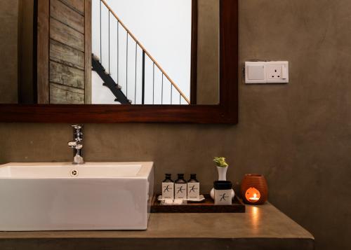 uma casa de banho com um lavatório branco e um espelho. em Lario Resort Sigiriya em Sigiriya