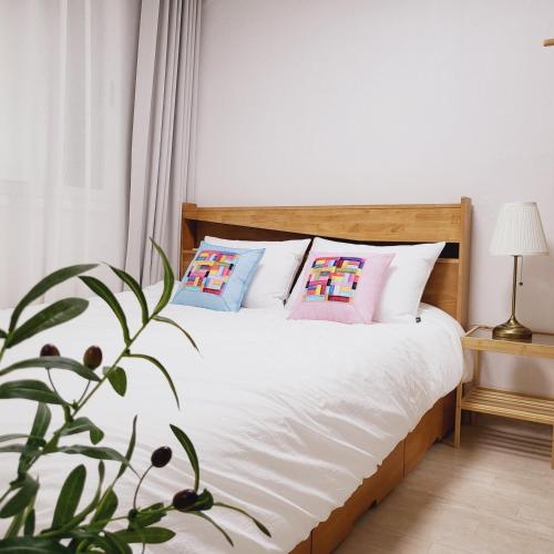 ein Schlafzimmer mit einem Bett mit Kissen und einer Pflanze in der Unterkunft 1978 stay in Seoul