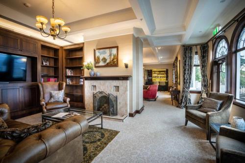 a living room with a couch and a fireplace at Hackthorne Gardens Luxury Accommodation in Christchurch