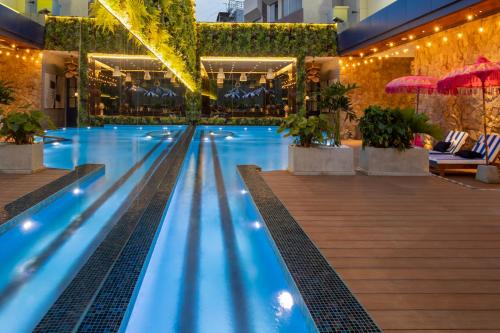 a swimming pool with lights and plants in a building at Ashley Tugu Tani Menteng in Jakarta