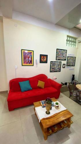 a living room with a red couch and a coffee table at Acogedora Habitación in Sucre