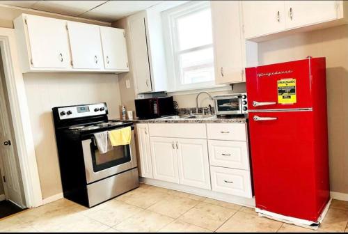 La cuisine est équipée d'un réfrigérateur rouge et de placards blancs. dans l'établissement Niagara View Inc LaSalle Av 3+Bd R,1.5 Bth, Parkng, à Niagara Falls