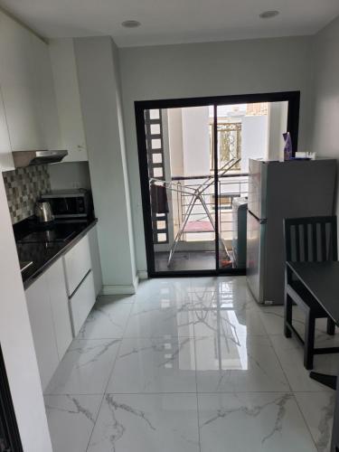 a kitchen with a refrigerator and a view of a balcony at PND apartment 코너룸 한국식 콘도 in Vientiane