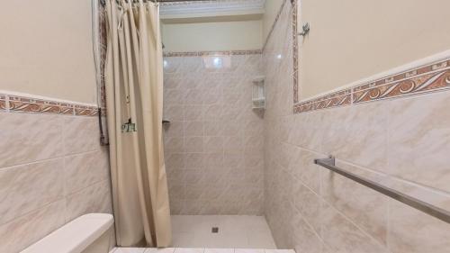 uma casa de banho com um chuveiro, um WC e um lavatório. em Hostal Pichincha em Cuenca