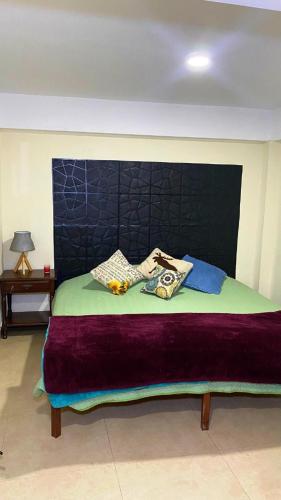 a bedroom with a large bed with a blue headboard at Encantadora habitación in Sucre