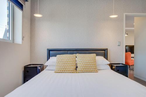 een slaapkamer met een bed met 2 kussens erop bij Cosy 1-Bedroom Apartment Close to the City in Sydney