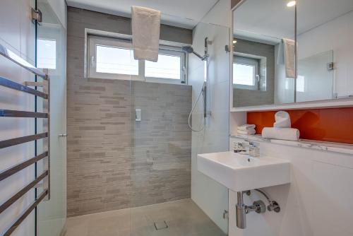 a bathroom with a sink and a shower at Cosy 1-Bedroom Apartment Close to the City in Sydney