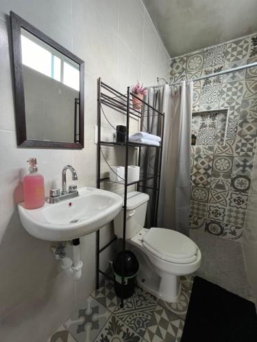 uma casa de banho com um lavatório, um WC e um espelho. em Casa Tezcal em Oaxaca de Juárez