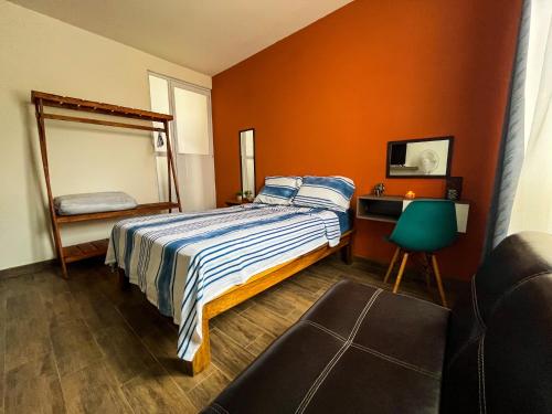 um quarto com uma cama, um espelho e uma cadeira em Casa Tezcal em Oaxaca de Juárez