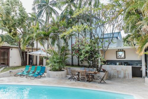 a resort with a pool and a table and chairs at COLIVER - COLIVING A LA RÉUNION in Saint-Pierre