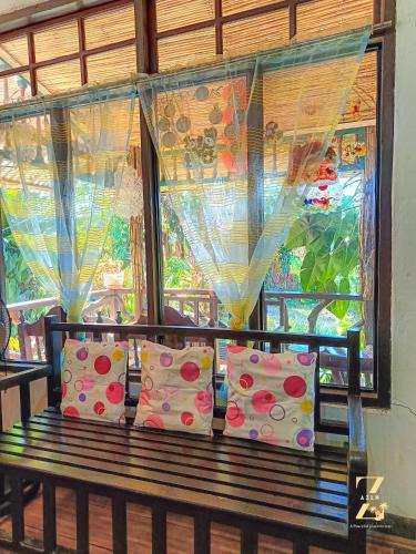 a bench with pillows sitting in front of a window at A. Zaragosa Lodging House in Inandeng