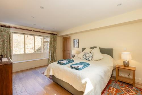 sypialnia z dużym łóżkiem i oknem w obiekcie Long Shed Cottage w mieście Thirsk