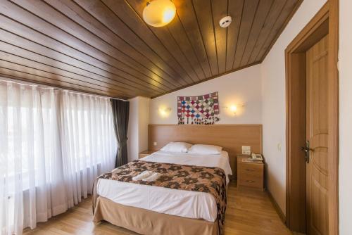 - une chambre avec un grand lit et un plafond en bois dans l'établissement Deniz Houses, à Istanbul