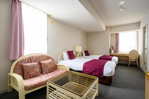 a hotel room with a bed and a chair at hotel miura kaen in Takikawa