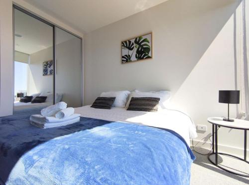a bedroom with a large bed with towels on it at Charming Central Apartment Home RundleMall in Adelaide