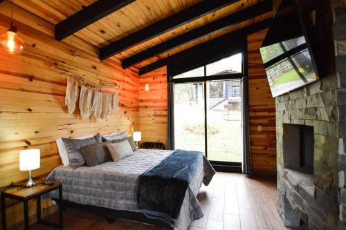 um quarto com uma cama e uma lareira de pedra em Cabaña Mirtus em Mazamitla