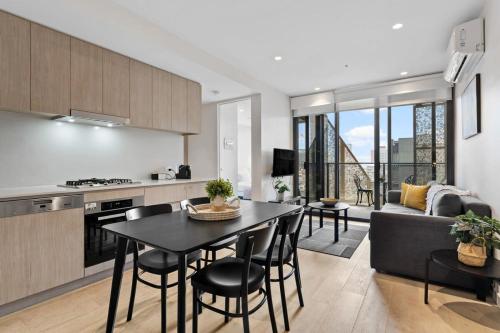 a kitchen and living room with a table and chairs at Heart of Adelaide Luxuy Apt Rundle Mall in Adelaide