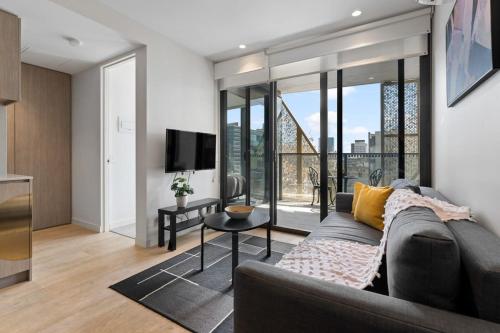 a living room with a couch and a tv at Heart of Adelaide Luxuy Apt Rundle Mall in Adelaide