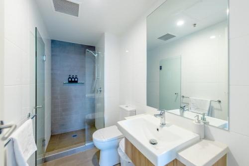 een witte badkamer met een wastafel en een toilet bij Walk to Central Market Parking GYM&POOL City View in Adelaide