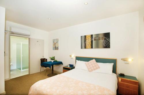 Habitación de hotel con cama y silla azul en CBD premium location Studio en Adelaida