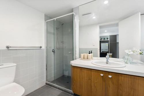 a bathroom with a toilet and a sink and a shower at CBD Modern 2BR Free Parking in Adelaide