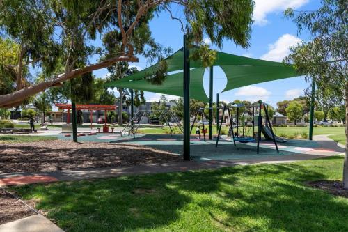 a playground with a green canopy in a park at Lovely Renovated 2BR Townhouse WiFi Parking in Sturt